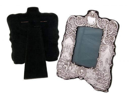 A Rare and exquisite pair of Asprey’s Silver Fox Hunting Photograph Frames together with matching hand mirror and a pair of hair brushes Embossed with a fox hunting scene, starting at the meet with Country House in the background following through to hounds in full cry, fox masks, hounds heads, hunting horns, whips etc. The frames have bottle green watermark silk and velvet lining.
