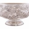 A magnificent and rare large Silver Victorian Rose Bowl with a chased fox hunting scene, depicting three and a half couple of hounds pursuing a fox in open landscape with the huntsman jumping a post and rail fence, a gentleman mounted with top hat and a house, most likely Ascott house. Makers: James Berkeley Hennel, London 1884. Includes Company Trade Mark. Weight 55 Ounces. Gilt Interior. IMPORTANT Rothschild connection. The Inscription is set between two oak trees and reads, “Given by Leopold De Rothschild, Won By W. Stewart-Freeman’s Folly, Ascott Cup 1887”